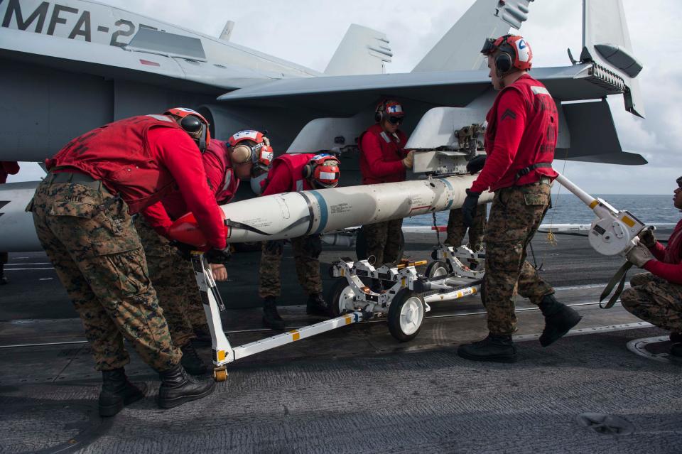 Marines assigned to the Navy Fighter Attack Squadron (VMFA) 251 Thunderbolts remove an AGM-88 high-speed anti-radiation missile (HARM) training missile from an F/A-18C Hornet on the carrier's flight deck. Nimitz-class planes USS Theodore Roosevelt (CVN 71).