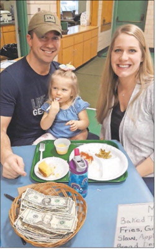 Tim and Katelyn Fuerstenberg take a break from working the annual fish fry at Zion Lutheran Church in Monroe to eat with their daughter Roselyn in 2019. Several Lenten fish fries have been scheduled this year.