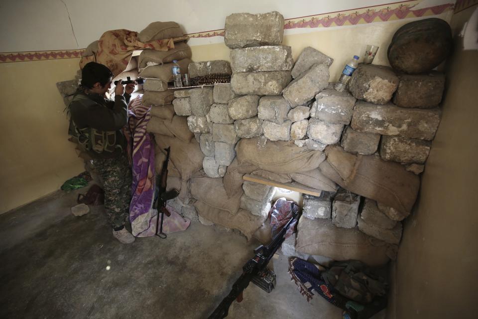 FILE - In this Jan. 29, 2015 file photo, a fighter of the Turkey-based Kurdish Workers' Party (PKK) uses his binoculars to look towards the Islamic State Group's base in the city of Sinjar, northern Iraq. Syria’s Kurds have been America’s partner in fighting the Islamic State group for nearly four years. Now they are furious over an abrupt U.S. troop pull-back that exposes them to a threatened attack by their nemesis, Turkey. The surprise U.S. pull-back from positions near the Turkish border, which began Monday, Oct. 7, 2019, stung even more because the Kurds have been abandoned before by the U.S. and other international allies on whose support they'd pinned their aspirations. (AP Photo/Bram Janssen, File)