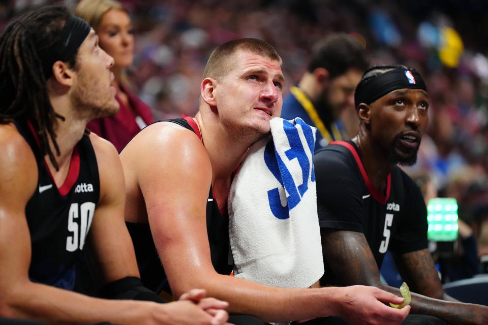 The Denver Nuggets' Nikola Jokic (center) watched from the bench during the third quarter against the Minnesota Timberwolves in Game 7 at Ball Arena.