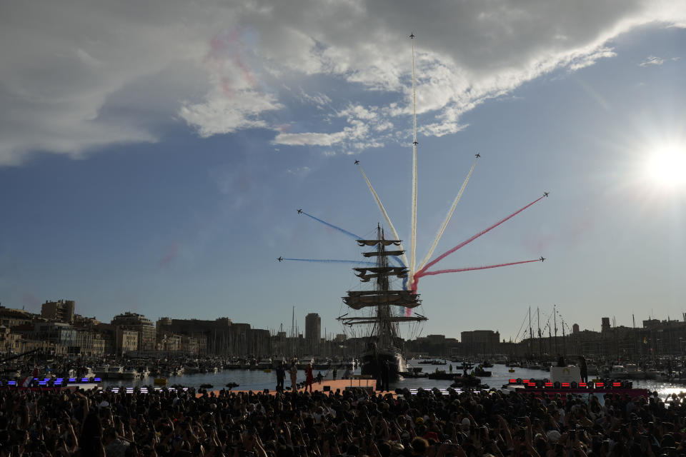 The Patrouille de France aerobatics demonstration aircraft leave a tricolor trail of smoke in the sky as the Belem, the three-masted sailing ship bringing the Olympic flame from Greece, enters the Old Port in Marseille, southern France, Wednesday, May 8, 2024. The torch was lit in Greece last month before it was officially handed to France. The Paris 2024 Olympic Games will run from July 26 to Aug.11, 2024. (AP Photo/Thibault Camus)