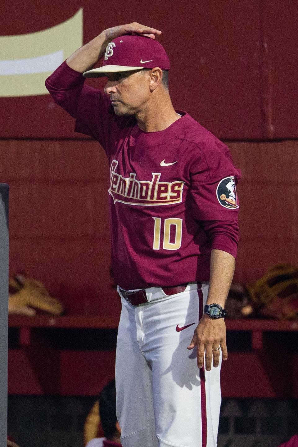 Florida State head coach Link Jarrett signals a play to the runners on base. The Florida Gators defeated the Florida State Seminoles 9-5 on Tuesday, March 21, 2023. 