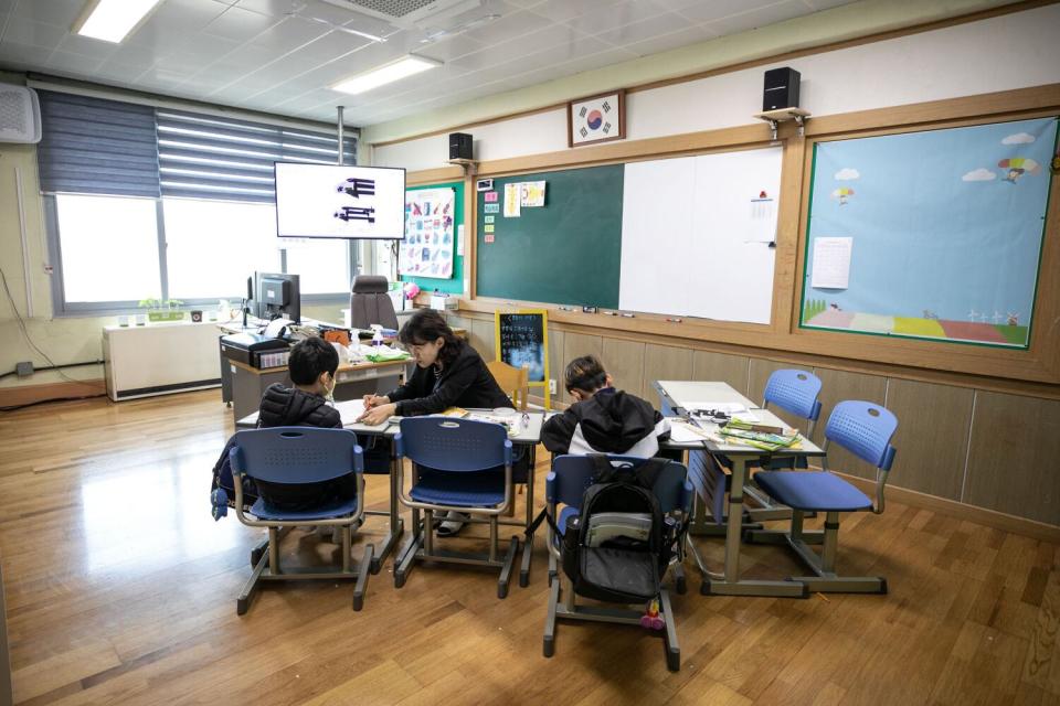 Principal Lee Eun-sook teaches Chinese characters to second-graders at Dochang Elementary.