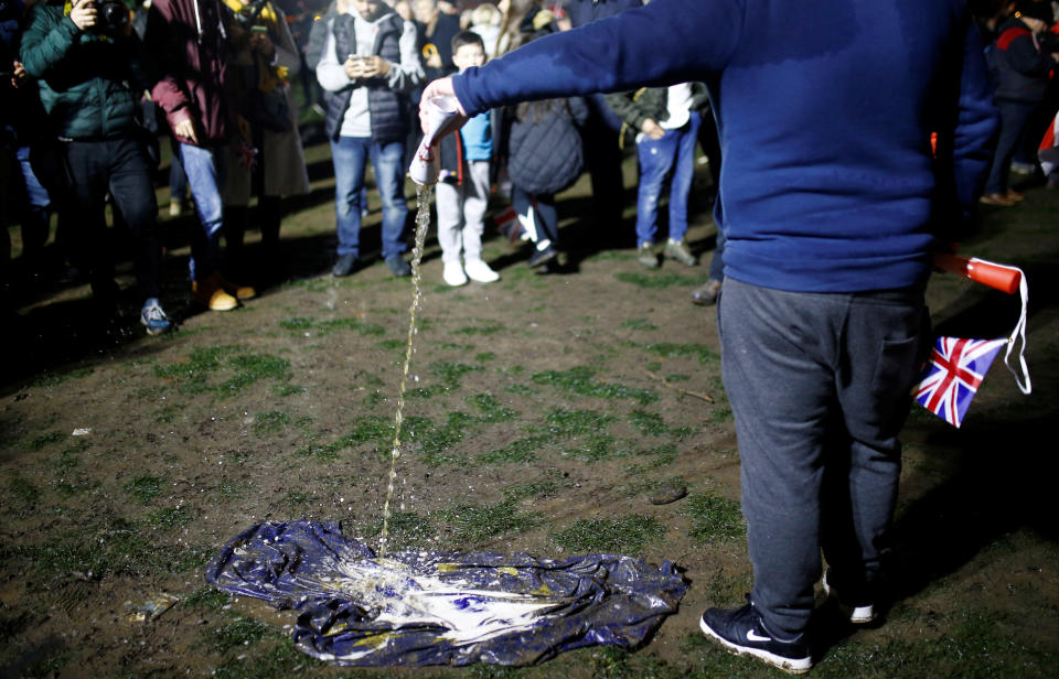 A person pours a beer on the European Union flag lying on the ground and covered with a mud on Brexit day in London, Britain January 31, 2020. REUTERS/Henry Nicholls