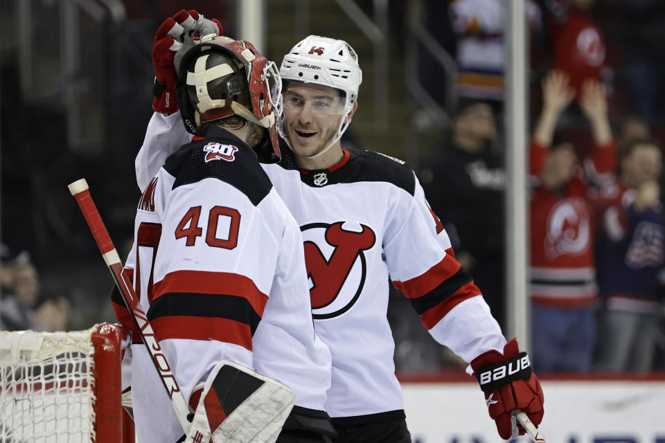 New Jersey Devils goaltender Akira Schmid (40) and Nathan Bastian celebrate after defeating the Philadelphia Flyers in an NHL hockey game Saturday, Feb. 25, 2023, in Newark, N.J. (AP Photo/Adam Hunger)