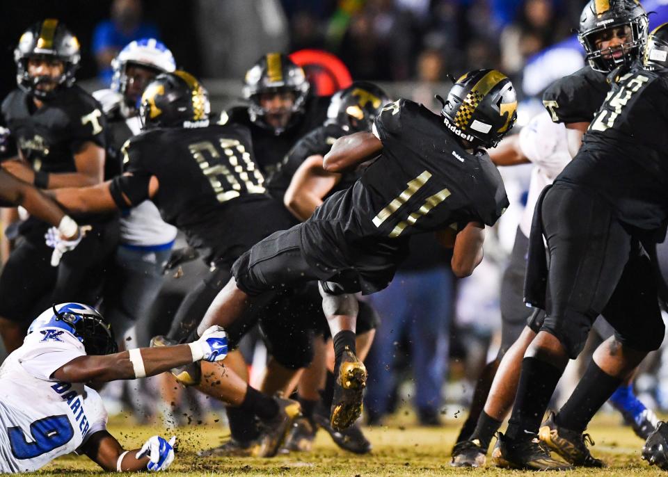 Apopka's Andre Phillips (9) stops Treasure Coast's Jamison Davis (11) in a high school football 8A state semifinal on Friday, Dec. 3, 2021, at South County Regional Stadium in Port St. Lucie. The Titans lost 21-0.