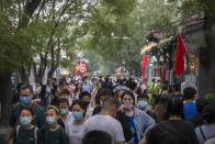 Crowds walk along a tourist shopping street on the first day of the National Day holiday period in Beijing, Saturday, Oct. 1, 2022. National Day marks the anniversary of the Oct. 1, 1949, founding of the People's Republic of China by then-leader Mao Zedong following a civil war. The mainland's former ruling Nationalist Party left for Taiwan, now a self-ruled democracy. (AP Photo/Mark Schiefelbein)