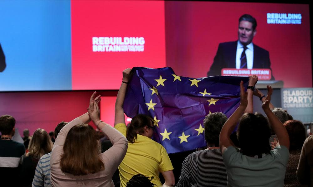 Conference attendees hold up an EU flag during shadow Brexit secretary’s speech