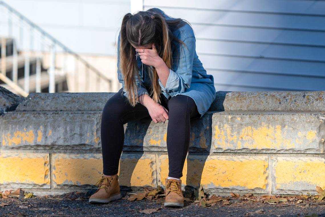 University of Idaho student Alaina Tempelis, of Seattle, prays with a cross in her hand Thursday, Nov. 17.