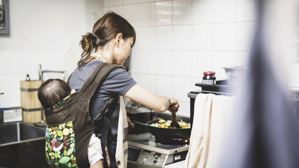 Mujer japonesa trabajando con su hijo.