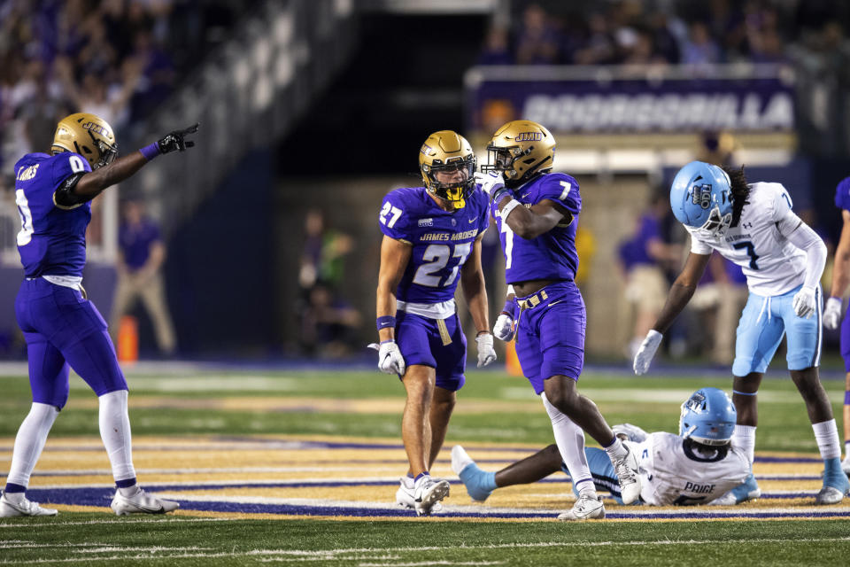 James Madison safety Jarius Reimonenq (7) celebrates with teammates Jacob Thomas (27) and Taurus Jones (0) after breaking up an Old Dominion pass on third down during the second half of an NCAA college football game Saturday, Oct. 28, 2023, in Harrisonburg, Va. (AP Photo/Mike Caudill)