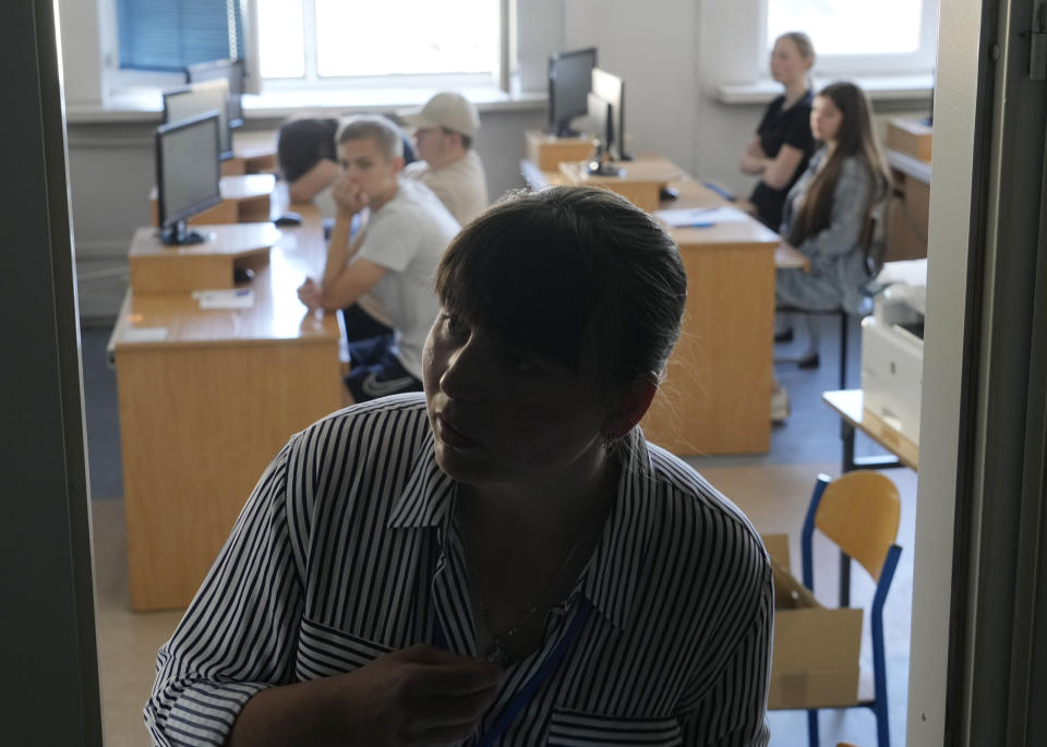 An exam administrator closes the door of a room where students were taking the Ukrainian final state examination, a test after high school for those who hope to attend university, in Warsaw, Poland, Wednesday June 7, 2023. Russian forces have destroyed 262 educational institutions and damaged another 3,019 in their invasion of Ukraine, according to government figures. For those who've fled to other countries, schooling is suffering in unprecedented ways, according to families, educators, experts and advocates. The effects of war and relocation combined with the challenges of studying in a new country are compounding educational setbacks for young refugees. (AP Photo/Czarek Sokolowski)