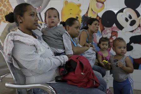 A woman who suspects her child (2nd L) to be infected with Zika virus, holds him as they wait at the emergency room in a hospital at the Petare slum in Caracas, Venezuela February 4, 2016. REUTERS/Marco Bello