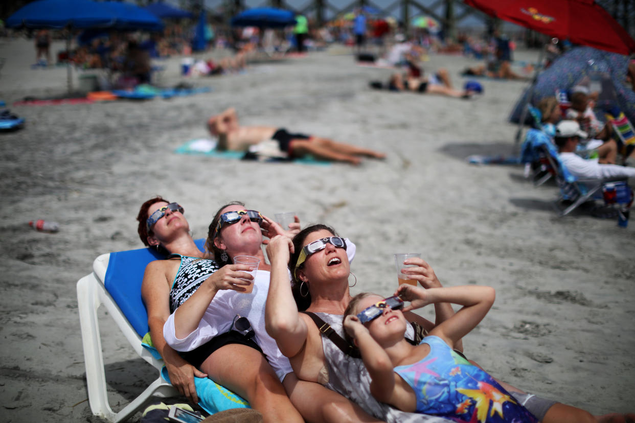 Un grupo de bañistas ve el eclipse solar en Folly Beach, Carolina del Sur, el 21 de agosto de 2017. (Travis Dove/The New York Times)