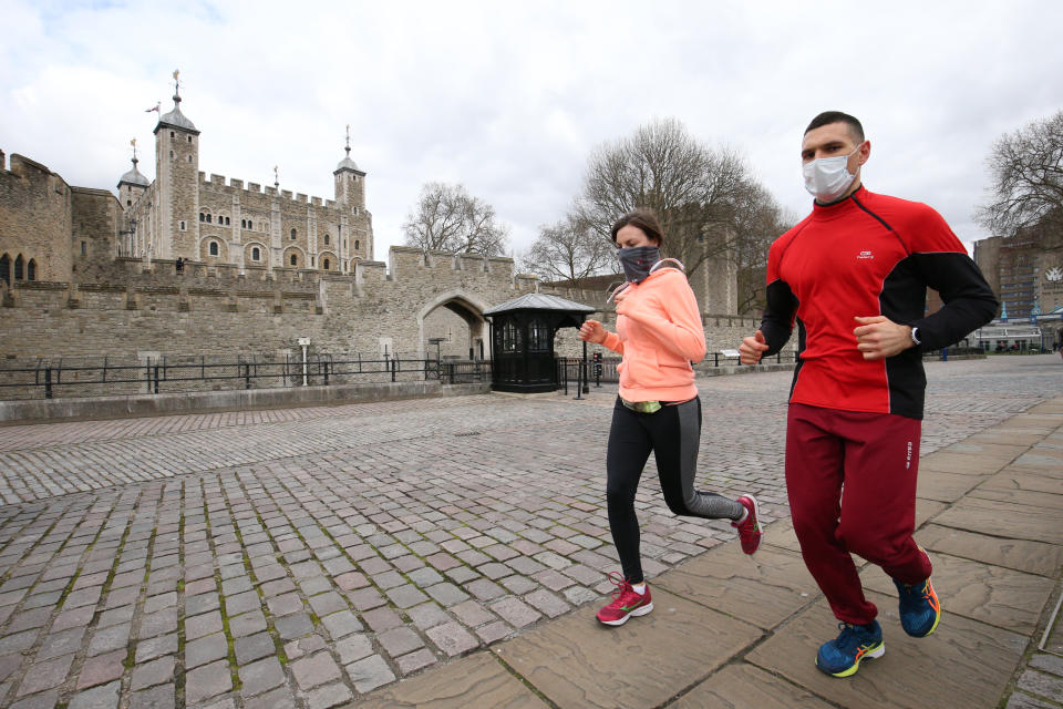Joggers by a quiet Tower of London, as the UK's coronavirus death toll reached 144 as of 1pm on Thursday, with around four in 10 of all deaths so far in London. (Photo by Jonathan Brady/PA Images via Getty Images)
