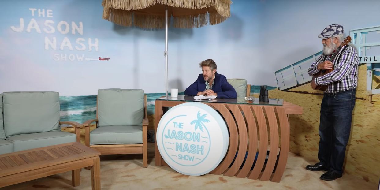 Jason Nash sitting behind a desk on "The Jason Nash" YouTube series