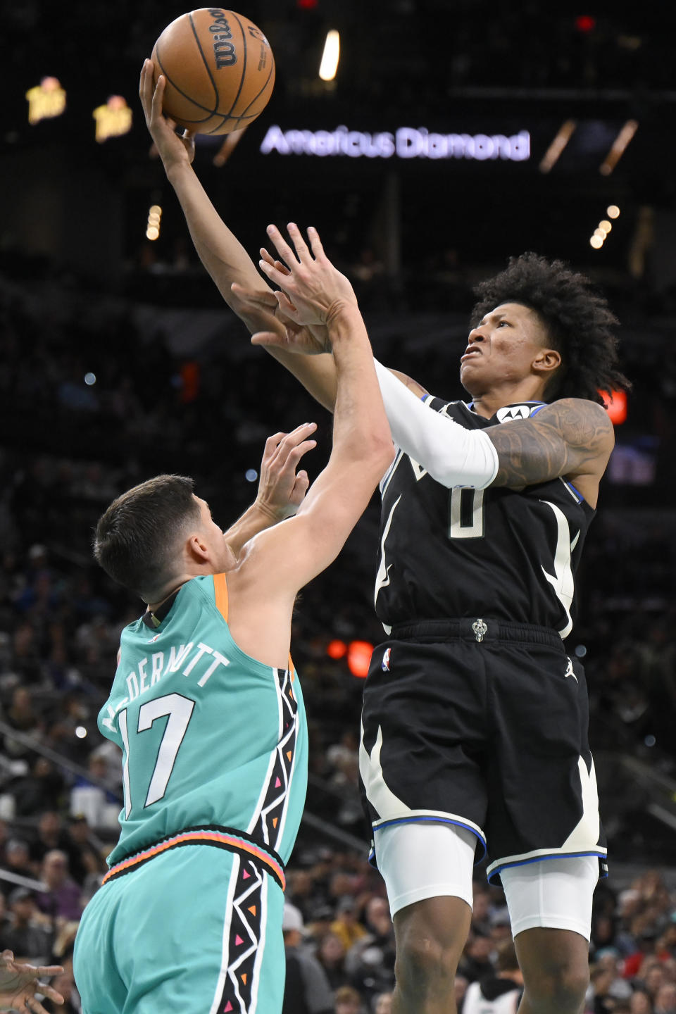 Milwaukee Bucks' MarJon Beauchamp (0) shoots against San Antonio Spurs' Doug McDermott during the second half of an NBA basketball game, Friday, Nov. 11, 2022, in San Antonio. San Antonio won 111-93. (AP Photo/Darren Abate)