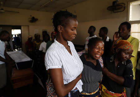 Relatives console family members as they walk past the coffin of Sumba Mufusho, who died after surviving for two days sheltering in a tree in the aftermath of Cyclone Idai, in Beira, Mozambique, March 23, 2019. REUTERS/Siphiwe Sibeko