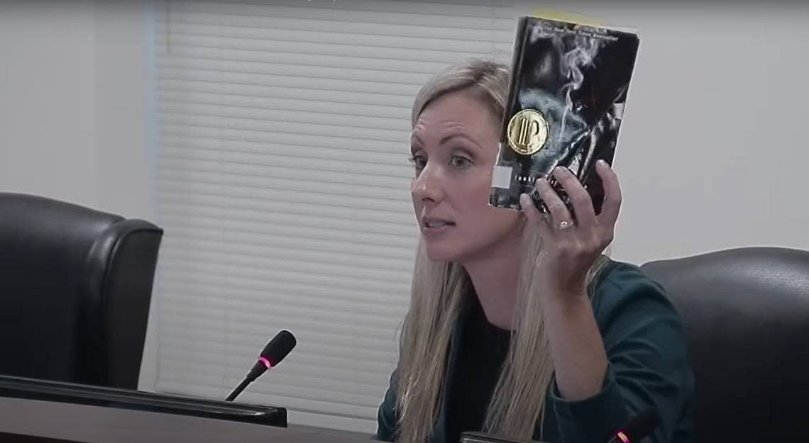 Laura Blackwell, vice chair of the Cabarrus County Schools board of education, holds up a copy of John Green’s 2005 “Looking for Alaska” during a meeting on Monday, Sept. 12, 2022. Blackwell read a passage from the book that depicted oral sex.