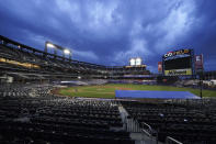 Members of the grounds crew close the field as the lights are turned down at Citi Field after the New York Mets and Miami Marlins walked before a baseball game Thursday, Aug. 27, 2020, in New York. Players jointly walked off the field after a moment of silence, draping a Black Lives Matter T-shirt across home plate as they chose not to play. (AP Photo/John Minchillo)