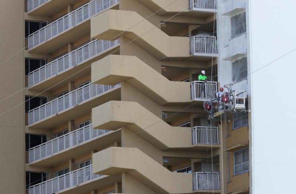 The Windsor and Maley Apartments in downtown Daytona Beach are undergoing a $59.25 million overhaul that will take a few years to complete. A painting crew is pictured working on the Windsor apartment building on Thursday.