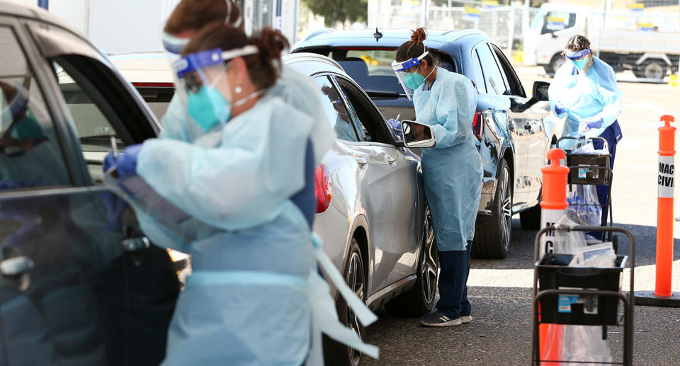 Nurses perform coronavirus tests at drive-thru clinic.