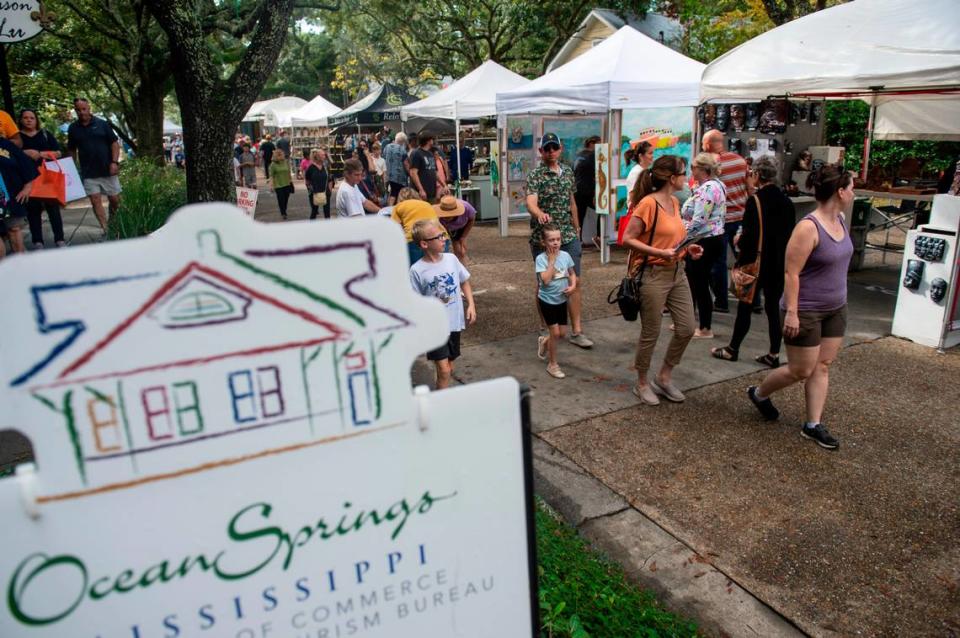 People walk among tents selling art along Washington Avenue during the Peter Anderson Festival in Ocean Springs on Sunday, Nov. 6, 2022.