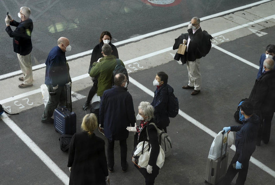 Members of the World Health Organization (WHO) team gather after arriving at the airport in Wuhan in central China's Hubei province on Thursday, Jan. 14, 2021. A global team of researchers arrived Thursday in the Chinese city where the coronavirus pandemic was first detected to conduct a politically sensitive investigation into its origins amid uncertainty about whether Beijing might try to prevent embarrassing discoveries. (AP Photo/Ng Han Guan)