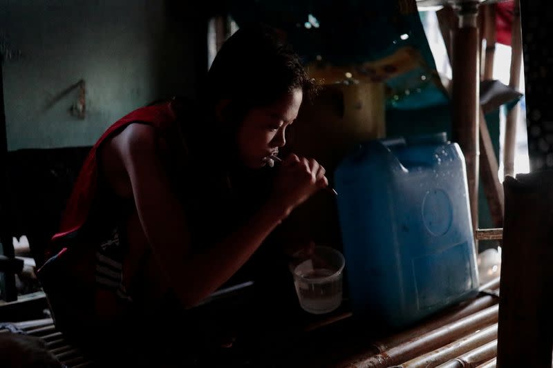 The Wider Image: Rising seas threaten early end for sinking village in Philippines