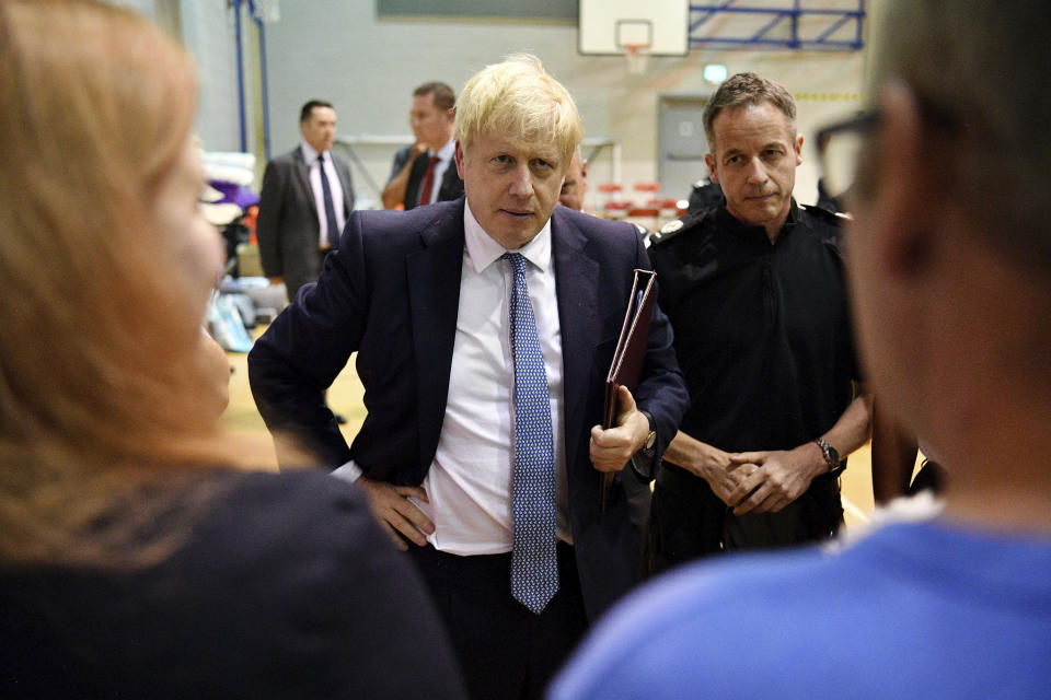 Britain's Prime Minister Boris Johnson meets with rescue crews and local residents during a visit to Chapel-en-le-Frith High School near the village of Whaley Bridge in Derbyshire, England, Friday, Aug. 2, 2019. A British military helicopter dropped sandbags Friday to shore up a reservoir wall as emergency services worked frantically to prevent a rain-damaged dam from collapsing. Engineers said they remain "very concerned" about the integrity of the 19th-century Toddbrook Reservoir, which contains around 1.3 million metric tons (1.5 million (U.S tons) of water. (Leon Neal/Pool photo via AP)