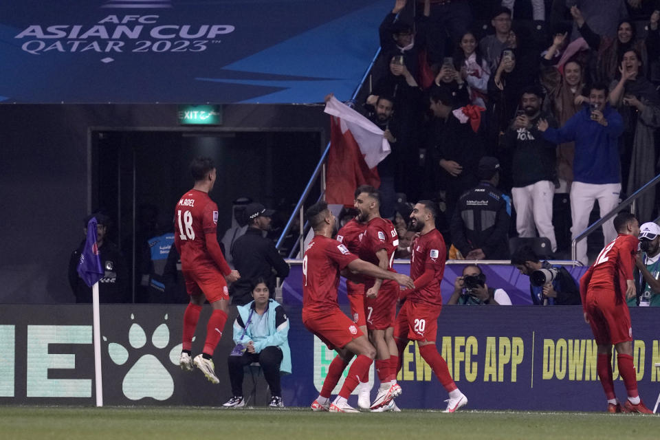 Bahrain's Ali Madan, center, celebrates with teammates after scoring the opening goal during the Asian Cup Group E soccer match between Malaysia and Bahrain at Jassim bin Hamad Stadium in Doha, Qatar, Saturday, Jan. 20, 2024. (AP Photo/Thanassis Stavrakis)