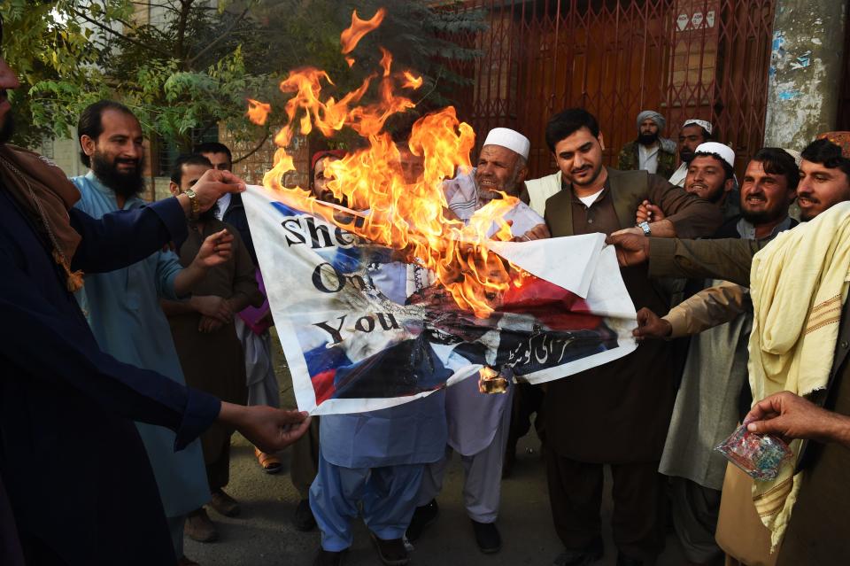 Demonstrators burn a poster with a picture of French President Emmanuel Macron with a footprint over his face during a protest following Macron's comments of Macron over Prophet Mohammed caricatures, in Quetta on October 26, 2020. - Pakistan on October 26 summoned French envoy to register protest over President Emmanuel Macron comments and for re-publishing of caricatures of Prophet Mohammed in a paris based magazine. (Photo by Banaras KHAN / AFP) (Photo by BANARAS KHAN/AFP via Getty Images)