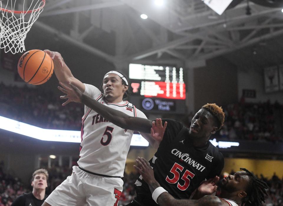 Texas Tech's guard Darrion Williams (5) and Cincinnati's forward Aziz Bandaogo (55) reach for the ball during their Big 12 game Saturday. Bandaogo had 10 points and 10 rebounds as UC knocked off the 15th-ranked Red Raiders 75-72.