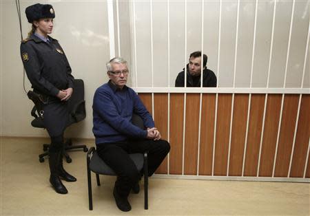 Greenpeace International activist Tomasz Dziemianczuk of Poland, one of 30 people arrested over a Greenpeace protest at the Prirazlomnaya oil rig, sits in a defendants' cage during a court session in St. Petersburg, November 19, 2013. REUTERS/Igor Podgorny/Greenpeace/Handout via Reuters