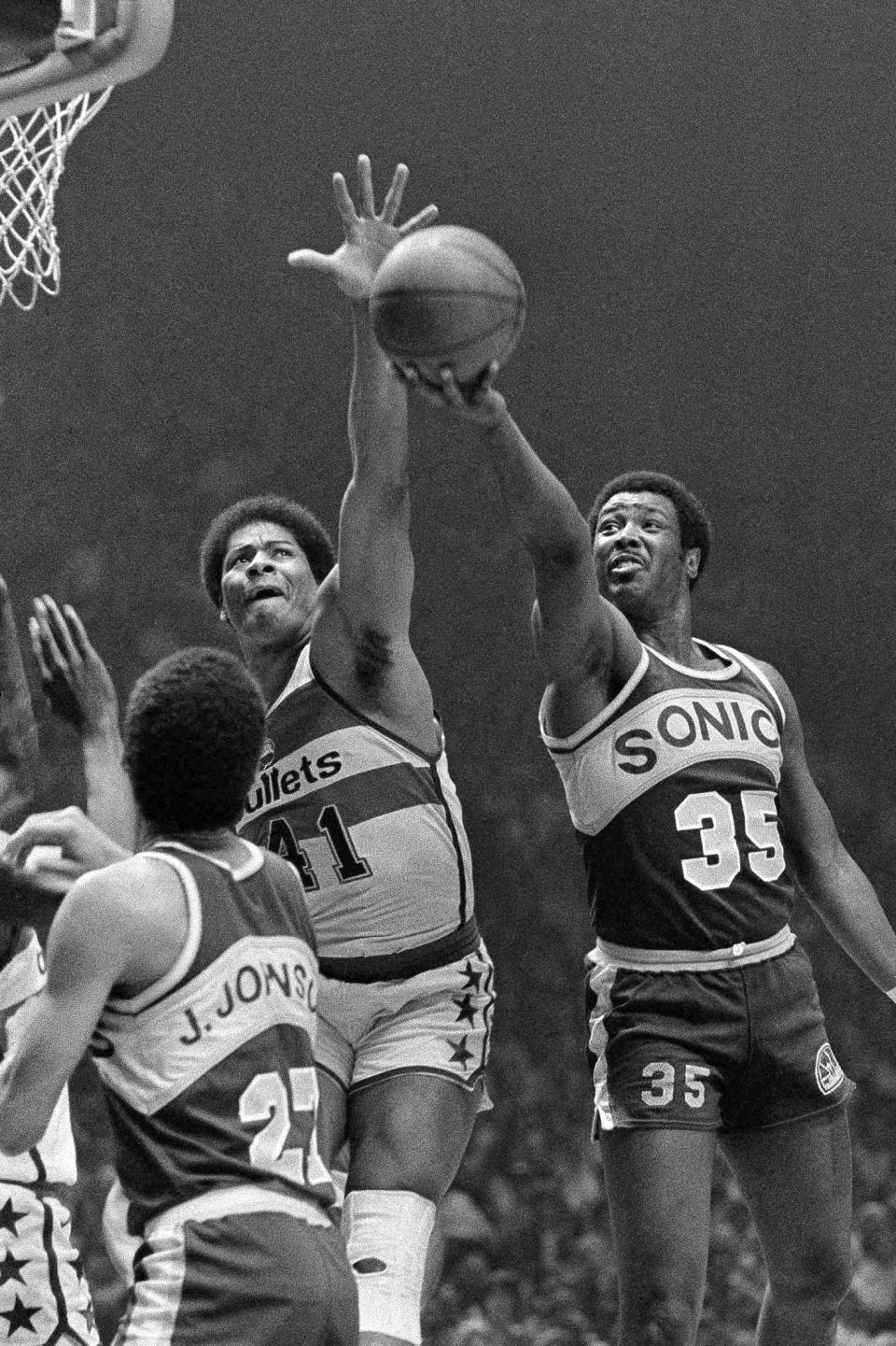 FILE - In this May 25, 1979, file photo, Washington Bullets' Wes Unseld (41) reaches to block a shot by Seattle Supersonics' Paul Silas ()35) during an NBA basketball game in Landover, Md. Unseld, the Hall of Fame center who led Washington to its only NBA championship and was chosen one of the 50 greatest players in league history, died Tuesday, June 2, 2020, after a series of health issues, most recently pneumonia. He was 74. (AP Photo/Smith, File)