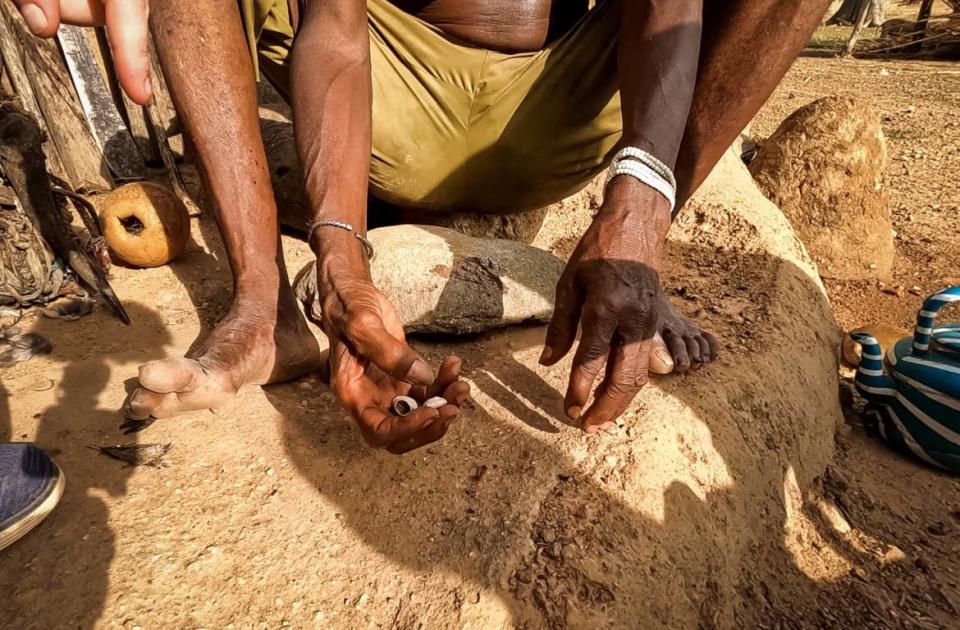 <div class="inline-image__caption"><p>A Vodun practitioner in Benin rolls tiny shells like dice.</p></div> <div class="inline-image__credit">Jody Bennett</div>