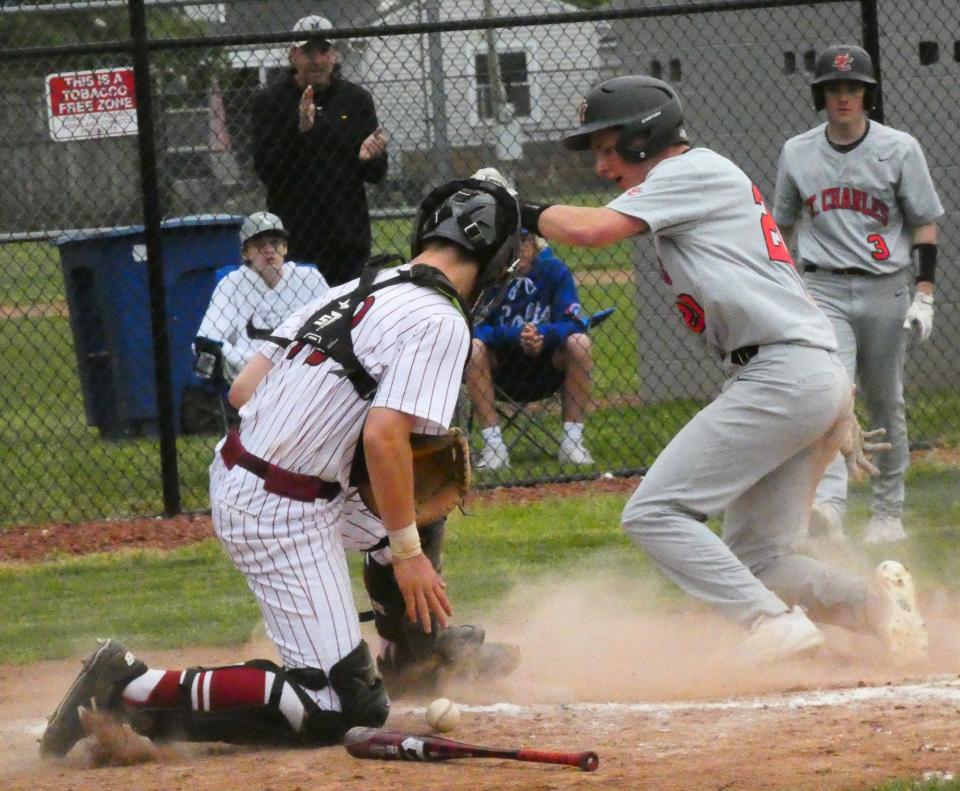St. Charles senior J.B. Meury scores on a ground ball as Newark freshman catcher Austin Rose blocks the throw home during a Division I second-round game at Joe Neff Field on Wednesday, May 18, 2022. The Wildcats fell 7-1 to the Cardinals.