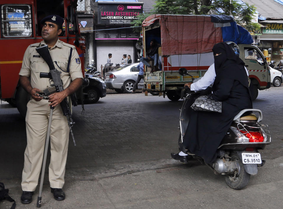 A police officer stands guards on a street in Mumbai, Saturday, Nov. 9, 2019. India's security forces were on high alert ahead of the Supreme Court's verdict Saturday in a decades-old land title dispute between Muslims and Hindus over plans to build a Hindu temple on a site where Hindu hard-liners demolished a 16th century mosque in 1992, sparking deadly religious riots. India's state broadcaster says that the country's top court rules disputed religious ground in favor of Hindus with alternate land for Muslims. (AP Photo/Rajanish Kakade)