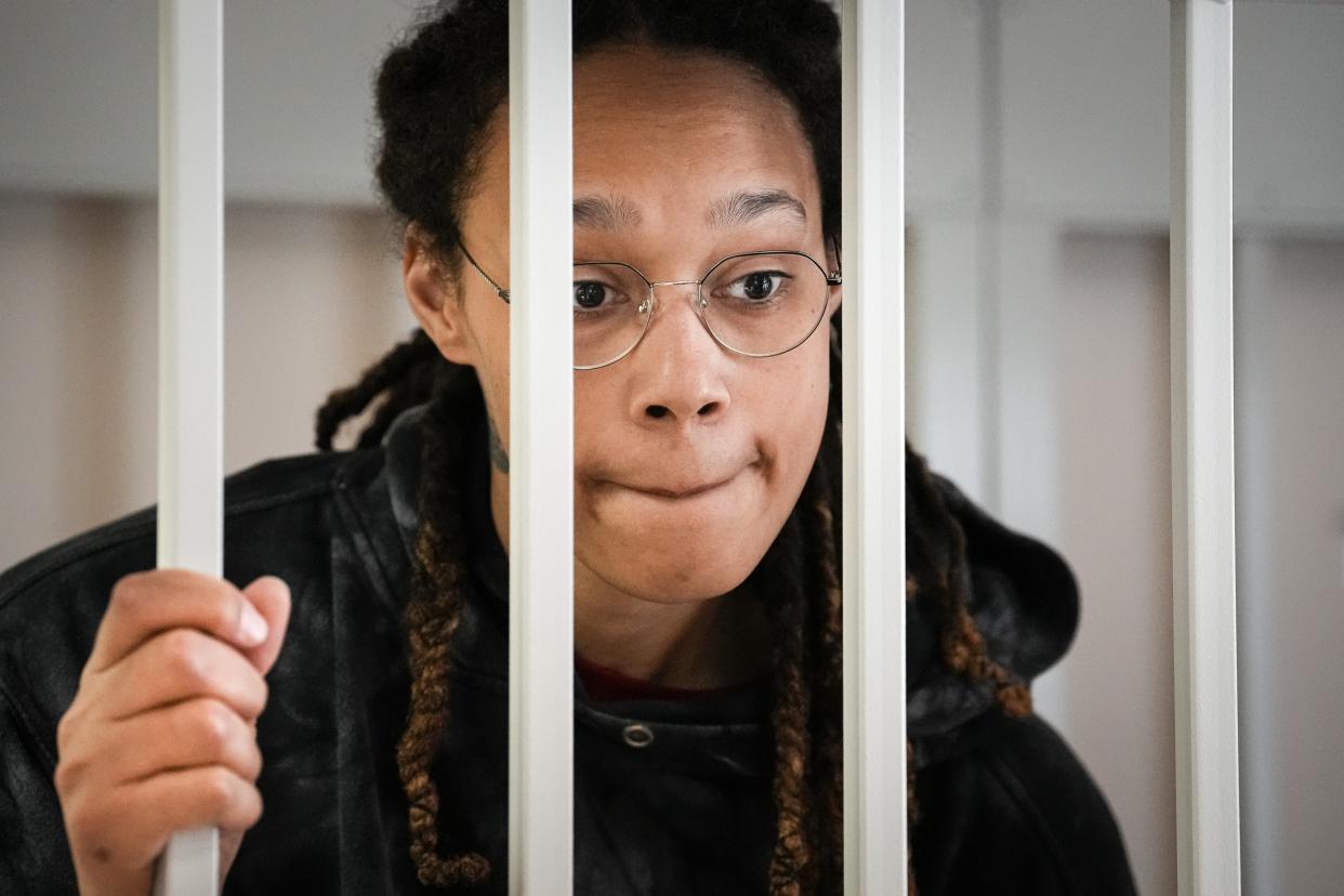 WNBA star and two-time Olympic gold medalist Brittney Griner speaks to her lawyers standing in a cage at a court room prior to a hearing, in Khimki just outside Moscow, July 26, 2022. (AP)