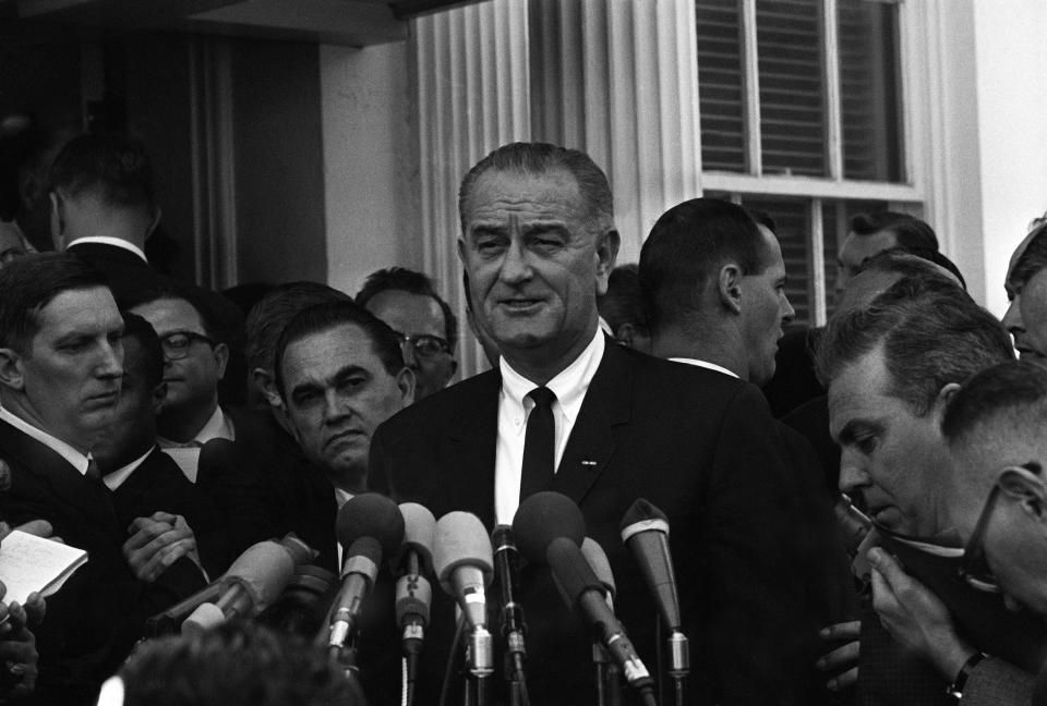 With Alabama Gov. George Wallace looking over his shoulder, President Lyndon Johnson, center, speaks to reporters outside the White House on March 13, 1965, in Washington, D.C. (Photo: AP)