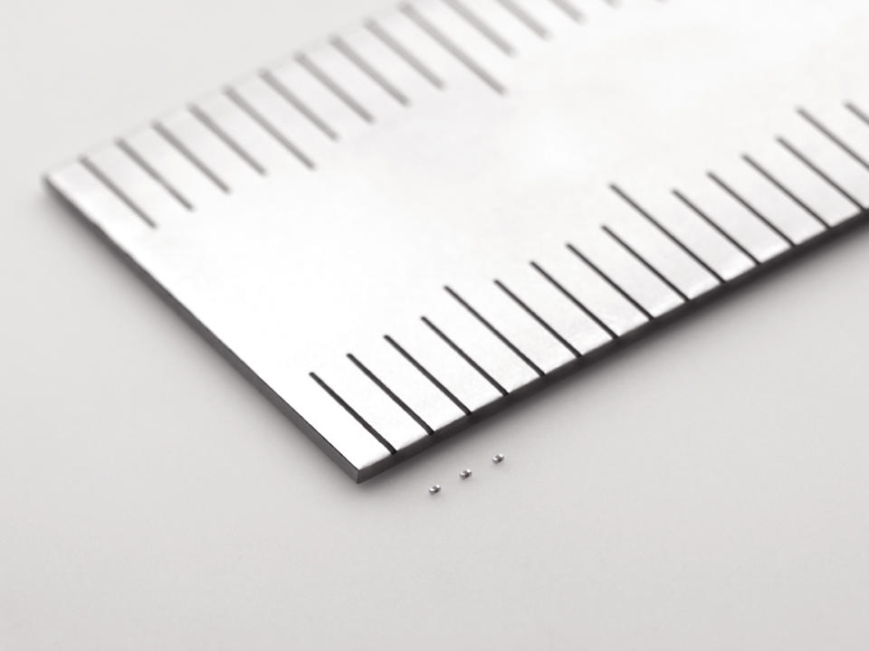 In this undated photo released by Murata Manufacturing Co., its latest capacitors, measuring just 0.25 millimeter by 0.125 millimeter, are shown next to a ruler. Small is big for Murata: The Japanese electronics maker has developed the world's tiniest component known as the capacitor. And that's big business. Capacitors, which store electric energy, are used in the dozens, even in the hundreds, in just about every type of gadget - smartphones, laptops, hybrid cars, medical equipment and digital cameras. (AP Photo/Murata Manufacturing Co.) NO SALES