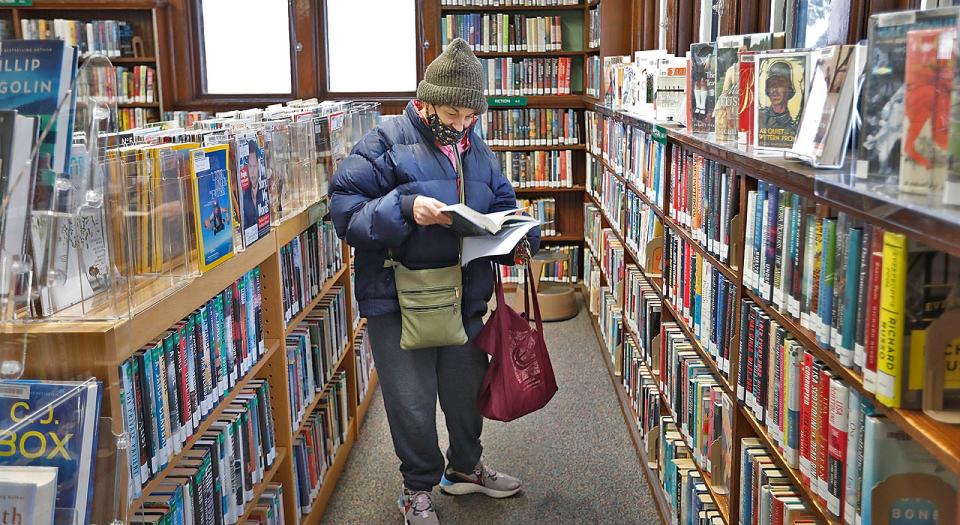 Resident Annie Ambrosio looks over a new mystery in the Wollaston library Monday, Jan. 23, 2023.