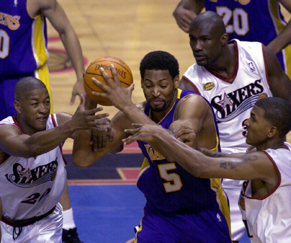 Philadelphia 76ers guard Eric Snow, left, Jumaine Jones and  Raja Bell, right, surround Los Angeles Lakers forward Robert Horry during the final seconds of Game 3 of the NBA finals, Sunday, June 10, 2001 in Philadelphia. The Lakers won 96-91.