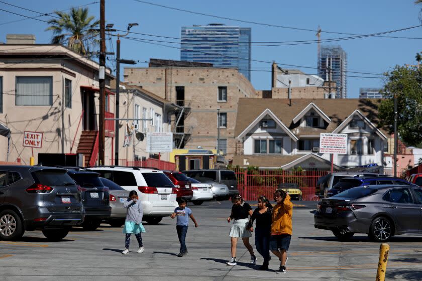 LOS ANGELES, CA - MAY 12: The Ritz-Carlton, hotel and luxury residences, and new upscale condominium construction, seen in the background, with dense housing in the Pico-Union neighborhood along S Hoover Street on Thursday, May 12, 2022 in Los Angeles, CA. Overcrowded housing in Pico-Union, considered the most overcrowded neighborhood in Los Angeles. (Gary Coronado / Los Angeles Times)