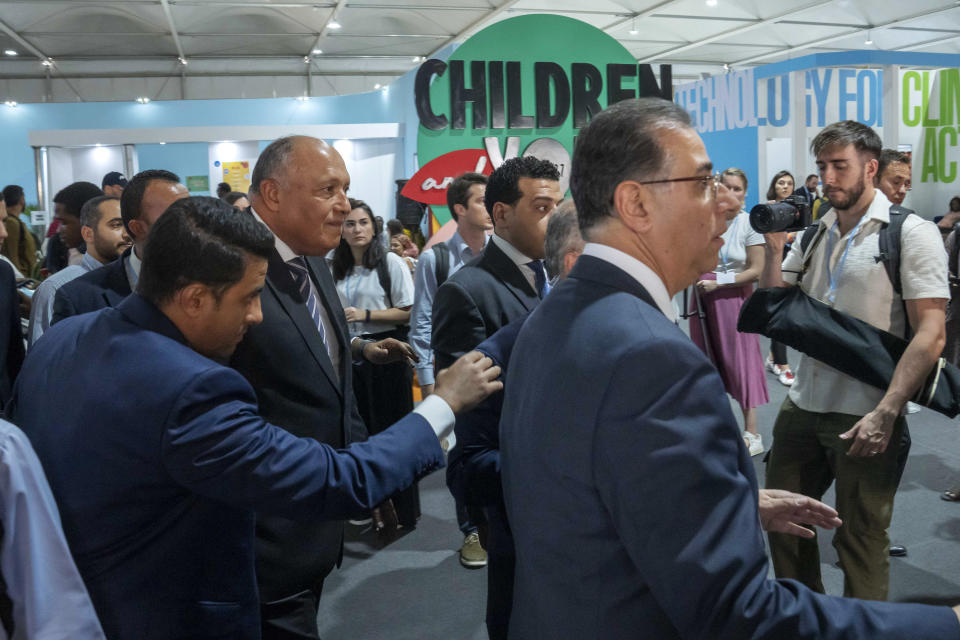 Sameh Shoukry, COP27 president, center left, walks in the youth pavilion at the COP27 U.N. Climate Summit, Wednesday, Nov. 9, 2022, in Sharm el-Sheikh, Egypt. (AP Photo/Nariman El-Mofty)