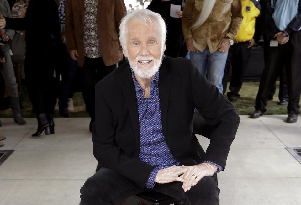 FILE - In this Oct. 24, 2017 file photo, Kenny Rogers poses with his star on the Music City Walk of Fame in Nashville, Tenn. Rogers has been admitted to a Georgia hospital for dehydration, according to his official Twitter account. A statement posted Friday, May 31, 2019, said he would remain there for physical therapy to "get his strength back" before being discharged. (AP Photo/Mark Humphrey, File)