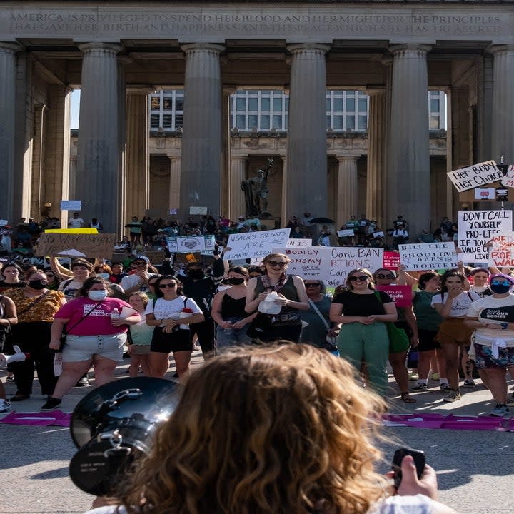 people lined up to peacefully protest outside a government building