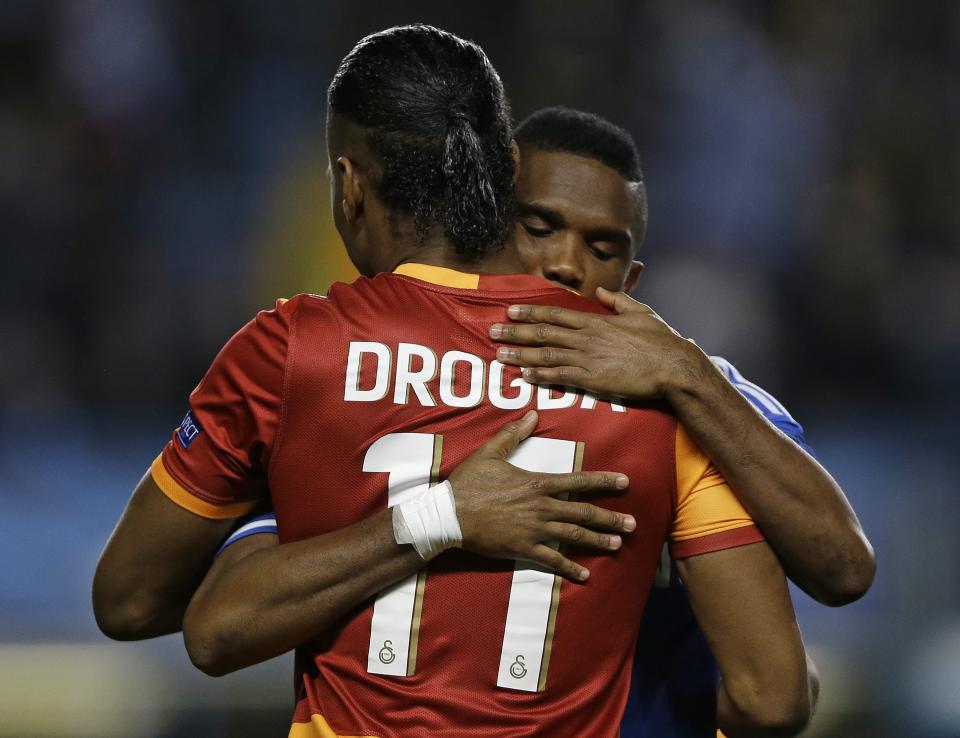 Galatasaray's Didier Drogba, left, and Chelsea's Samuel Eto'o embrace before the Champions League round of 16 second leg soccer match between Chelsea and Galatasaray at Stamford Bridge stadium in London Tuesday, March 18, 2014. (AP Photo/Kirsty Wigglesworth)