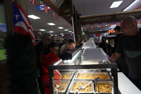 People buy Puerto Rican food at Willers Supermarket which specialises in Puerto Rican products, in Kissimmee, Florida, U.S., December 10, 2017. REUTERS/Alvin Baez