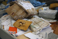 Eight years' worth of undelivered mail held by Israel is being processed, at the post office in the West Bank city of Jericho, Sunday, Aug. 19, 2018. In recent days the postal staff has been sorting through tons of undelivered mail in a room packed with letters, boxes and even a wheelchair. Postal official Ramadan Ghazawi says Israel did not respect a 2008 agreement to send and receive mail directly through Jordan. Israeli officials say the one-time release of 10.5 tons of mail was a "gesture." (AP Photo/Nasser Shiyoukhi)